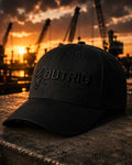 Black cap with 'Outrig Supply Co' logo against a sunset industrial background