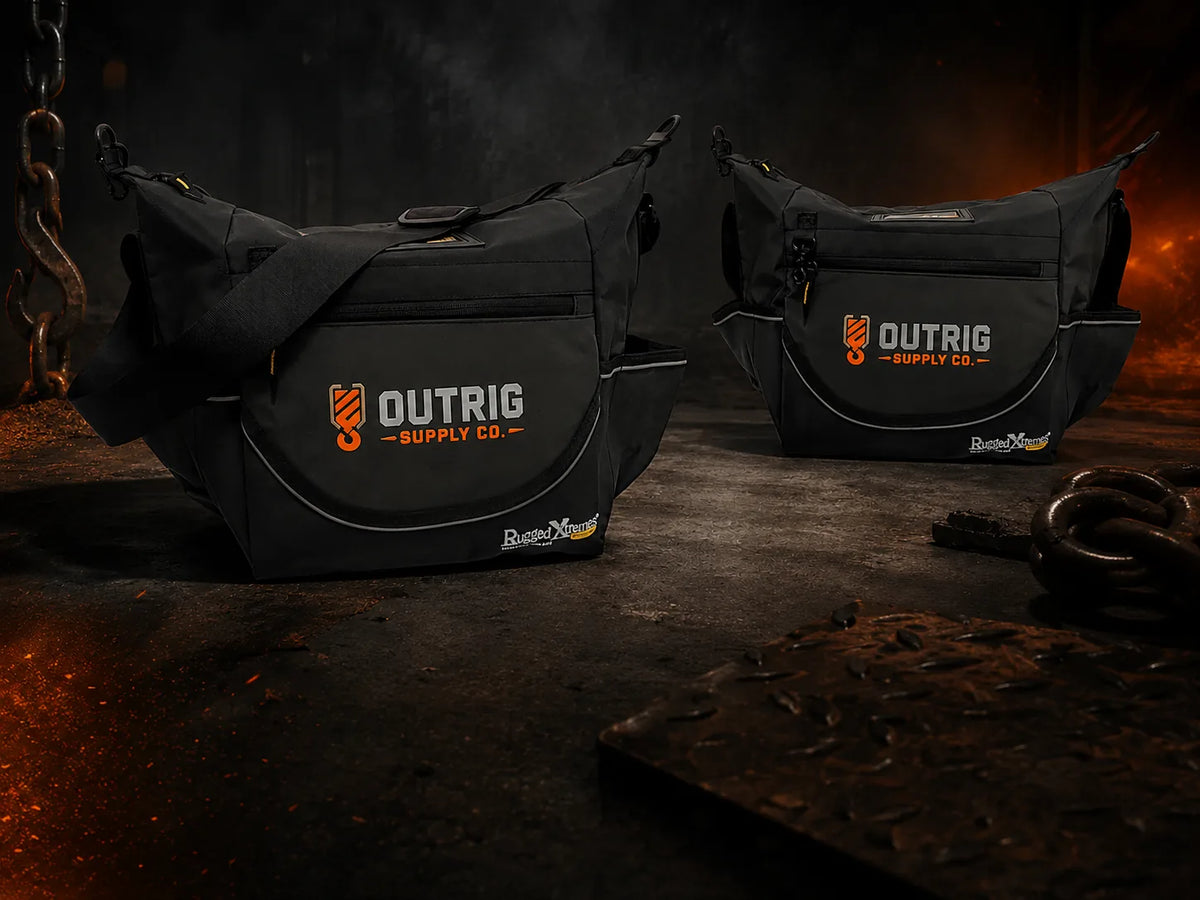Two Outrig Supply Co branded Rugged Xtremes 15L black insulated crib bags in an industrial worksite setting.